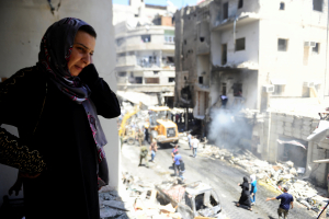 A woman inspects a damaged site after a suicide and car bomb attack in south Damascus Shi'ite suburb of Sayeda Zeinab, Syria June 11, 2016. <br/> REUTERS/Omar Sanadiki