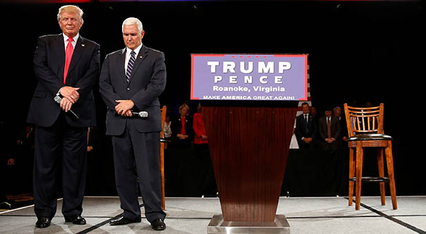 A video of Republican presidential nominee Donald Trump and Indiana Gov. Mike Pence bowing their heads as a Liberty University graduate prays the two politicians will be "able to stand firm against the vials of the enemy of God, against Satan" has gone viral.