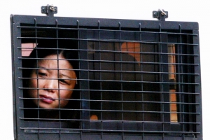 A mainland Chinese woman, that worked as a prostitute in Hong Kong, looks out from inside a police van September 19, 2002 before being sent back to China. A total of 85 prostitutes from mainland China were arrested during a raid at the territory's Shum Shui Po district, Hong Kong police said. (Photo: REUTERS/Bobby Yip)  <br/>